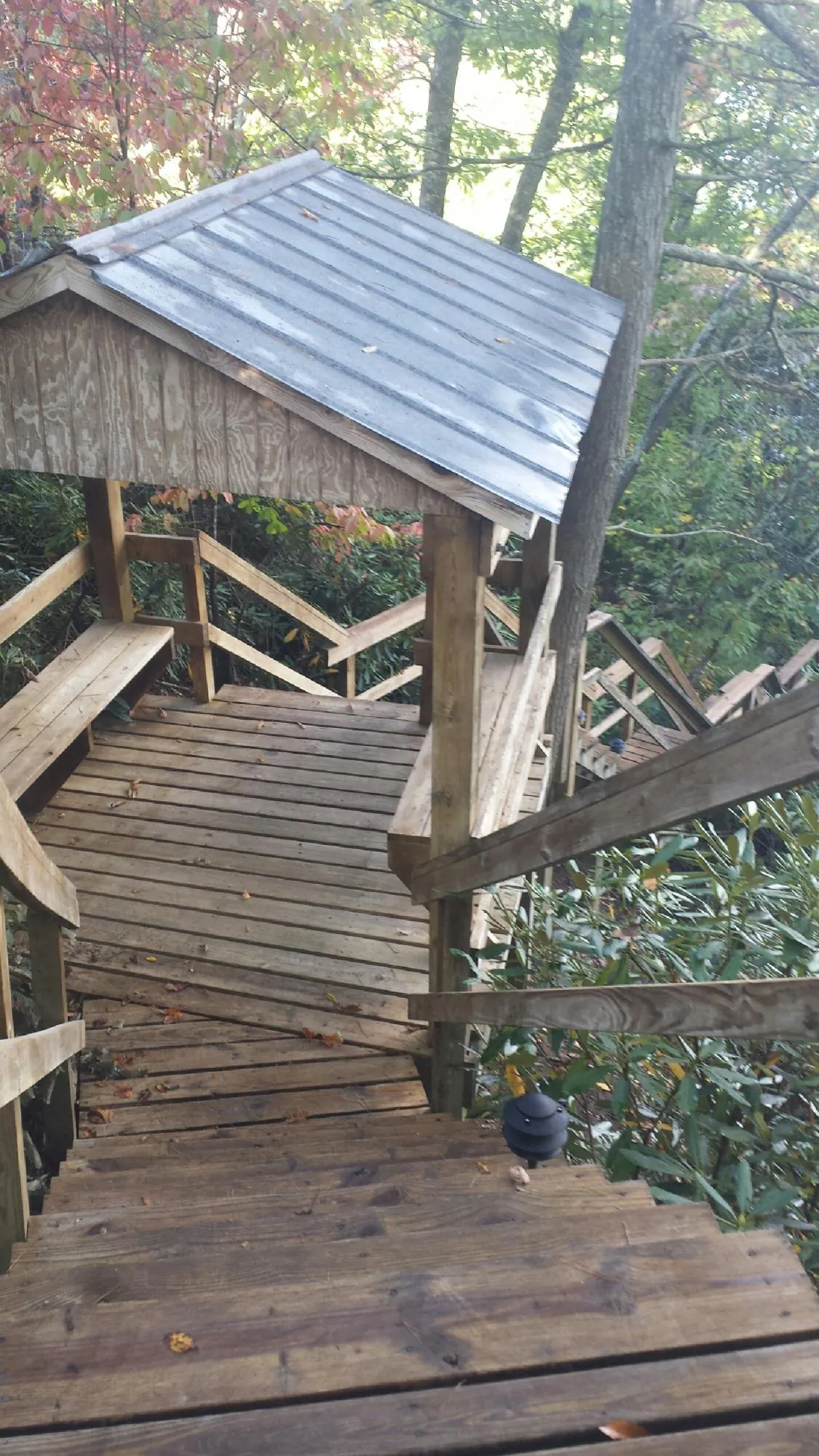 Metal roofed shelter over wooden steps on a wooded walkway — Skylight Repair & Installation work by our crew in Mashpee